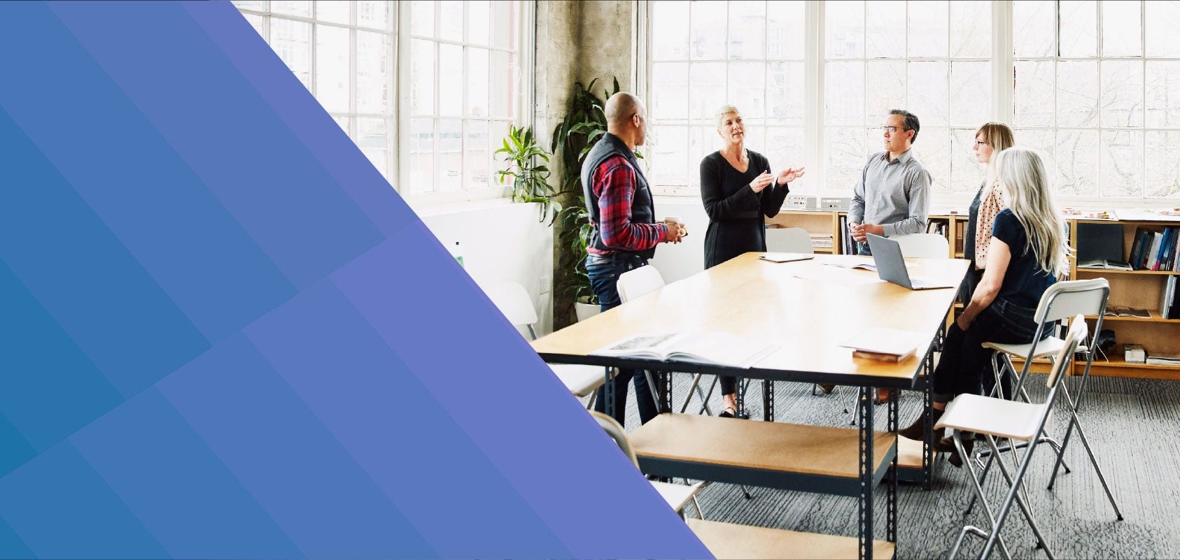 Teammates having a conversation around a meeting table.