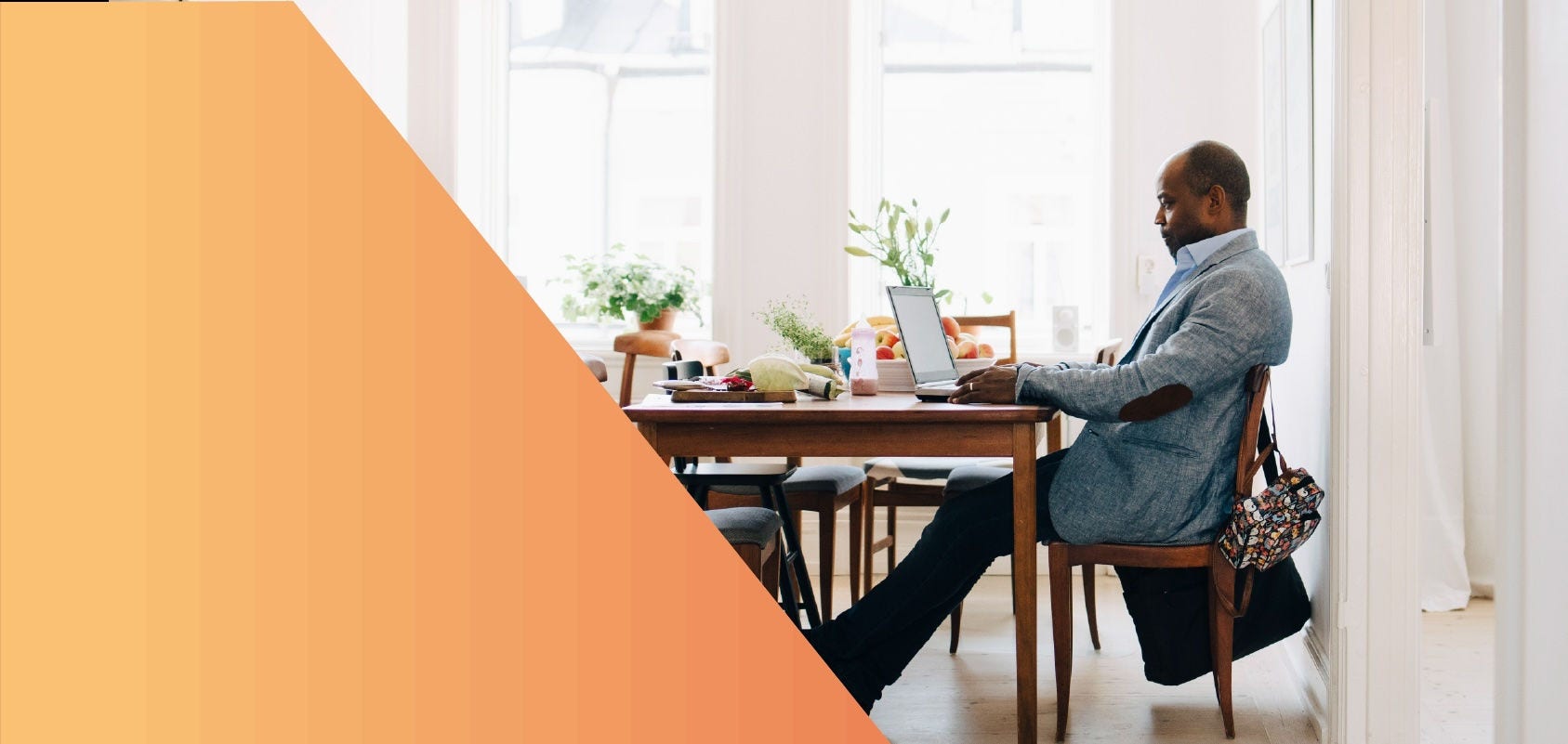 Man working on a laptop in his dining room.