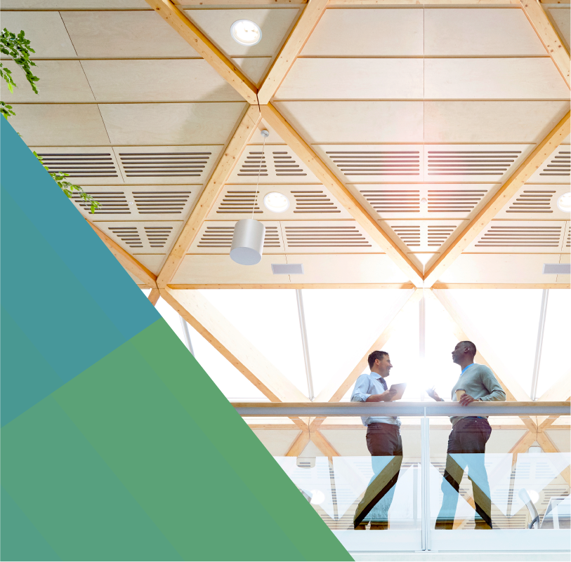Two male businessmen speaking on balcony in open office space
