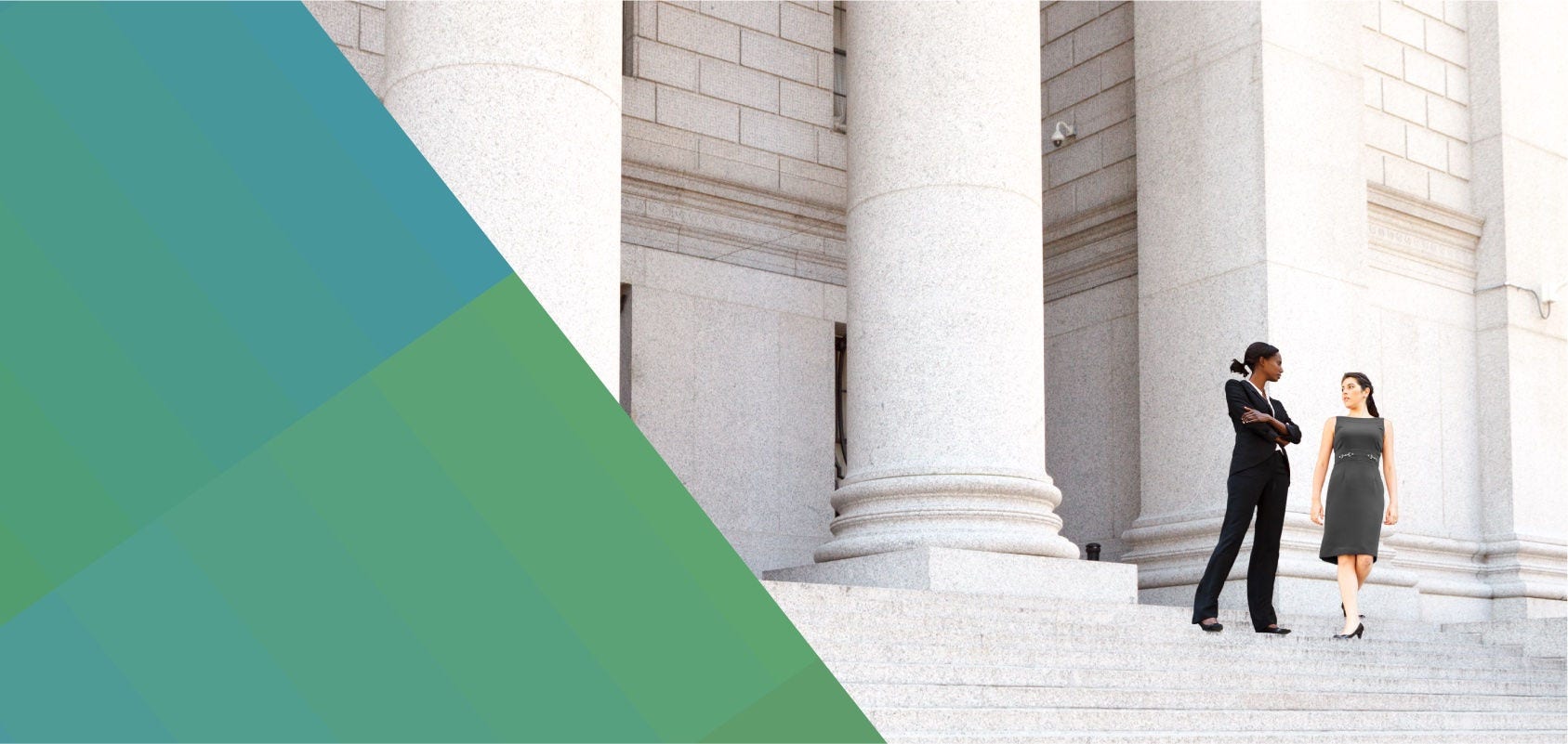 Two female lawyers on the steps of a courthouse.